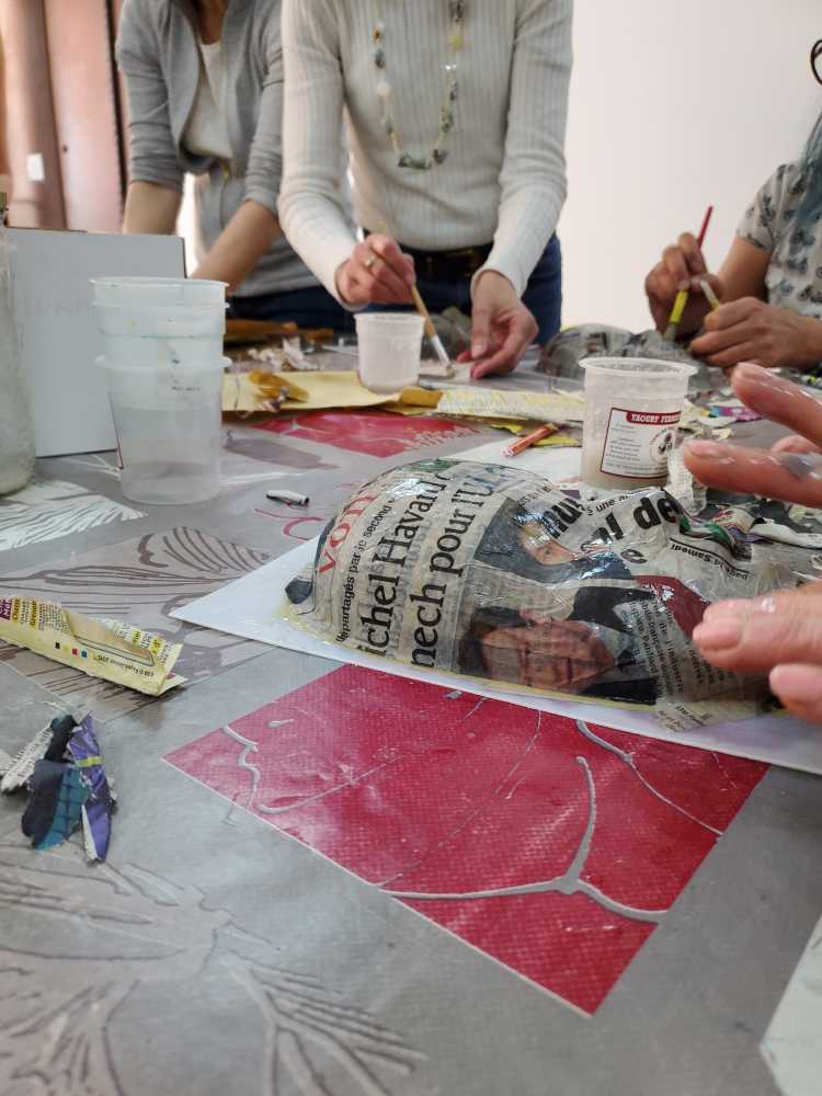 réalisation d'un masque en papier mâché avec plusieurs couches de papier journal