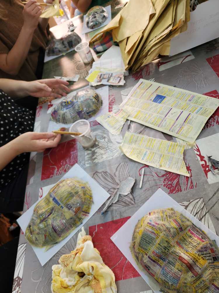 réalisation d'un masque en papier mâché avec plusieurs couches de papier journal